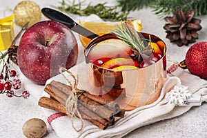 Hot mulled wine with fruits and spices in a copper pot