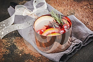 Hot mulled wine with fruits and spices in a copper pot