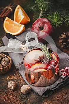 Hot mulled wine with fruits and spices in a copper pot