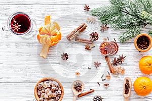 Hot mulled wine or grog cooking for new year celebration with oranges and spices ingredients on light background flat