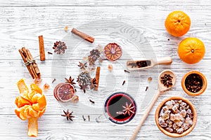 Hot mulled wine or grog cooking for new year celebration with oranges and spices ingredients on light background flat