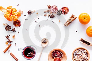 Hot mulled wine or grog cooking for new year celebration with oranges and spices ingredients on white background flat