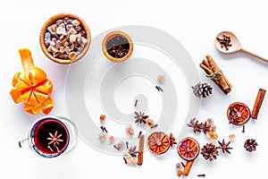 Hot mulled wine or grog cooking for new year celebration with oranges and spices ingredients on white background flat