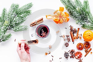 Hot mulled wine or grog cooking for new year celebration with oranges and spices ingredients on white background flat