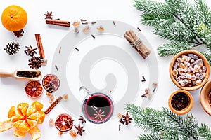 Hot mulled wine or grog cooking for new year celebration with oranges and spices ingredients on white background flat