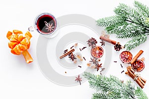 Hot mulled wine or grog cooking for new year celebration with oranges and spices ingredients on white background flat