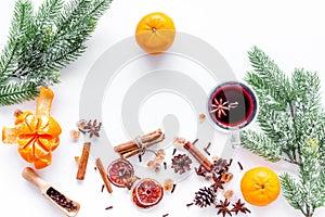 Hot mulled wine or grog cooking for new year celebration with oranges and spices ingredients on white background flat