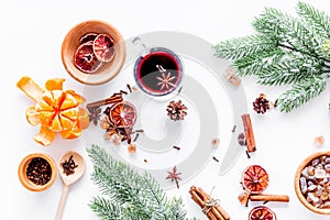 Hot mulled wine or grog cooking for new year celebration with oranges and spices ingredients on white background flat