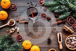 Hot mulled wine or grog cooking for new year celebration with oranges and spices ingredients on wooden background flat
