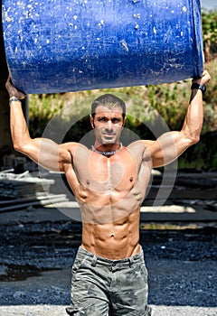 Hot, muscular construction worker shirtless carrying barrel