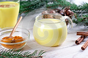 Hot New year and christmas drink from turmeric, Golden milk with fir branches