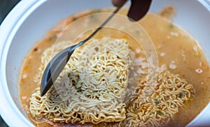Hot noodle Cup. Noodle cup Ready made. Eating Instant Noodles with a Plastic Fork. Junk food Instant noodles are eating the popul