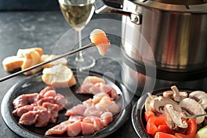 Hot oil fondue with pieces of meat and vegetables, to be fried in a pot with sizzling fat, gregarious festive dinner often served
