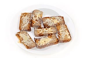 Hot open sandwiches with grated cheese on the white dish