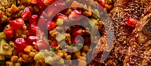 Hot peppered pork ribs on lukewarm lentil salt with fresh pomegranate seeds
