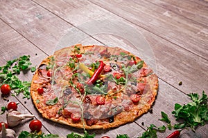 Hot pepperoni pizza with vegetables, chili pepper and ham. Pizza on a rustic background. Restaurant dishes. Copy space.