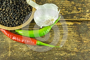 Hot peppers of different colors, black pepper and garlic