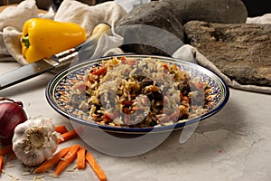 Hot pilaf with lamb or beef in a decorative national Uzbek plate with a traditional pattern.
