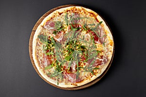 Hot pizza Prosciutto on a rustic wooden table.