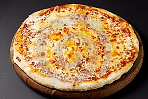 Hot pizza Quattro Formaggi on a rustic wooden table.