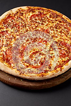 Hot pizza on a rustic wooden table.