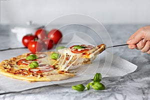 Hot pizza slice with melting cheese. Pizza with tomatoes and mozzarella