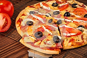 Hot pizza slice with melting cheese on a rustic wooden table