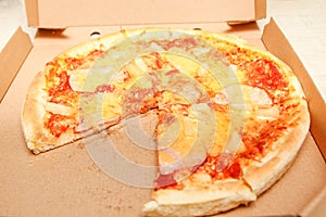 Hot pizza slice with melting cheese on a rustic wooden table