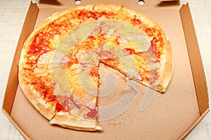 Hot pizza slice with melting cheese on a rustic wooden table