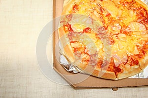 Hot pizza slice with melting cheese on a rustic wooden table