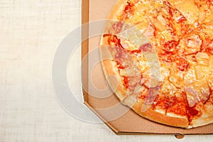 Hot pizza slice with melting cheese on a rustic wooden table