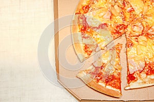 Hot pizza slice with melting cheese on a rustic wooden table