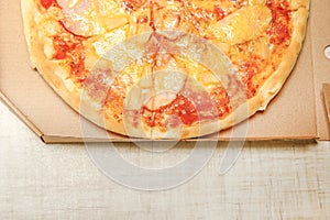 Hot pizza slice with melting cheese on a rustic wooden table