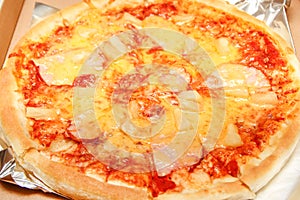 Hot pizza slice with melting cheese on a rustic wooden table