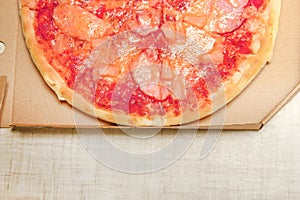 Hot pizza slice with melting cheese on a rustic wooden table