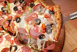 Hot pizza slice with melting cheese on a rustic wooden table