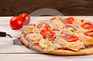 Hot pizza slice with melting cheese on a rustic wooden table