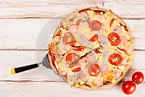 Hot pizza slice with melting cheese on a rustic wooden table