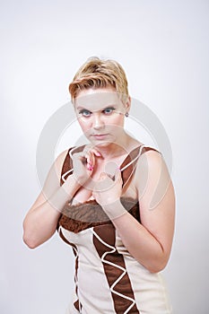 Hot plus size woman in fur carnival costume of primitive man on white background in Studio. a beautiful savage girl in a brown dre