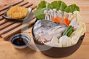 Hot pot of salmon head with mushroom, carrot, tofu, cabbage and