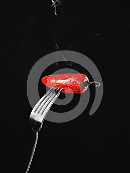 Hot Red chili Pepper with smoke, isolated on a black background