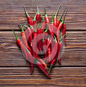 Hot red chilli pepper in pods on wooden table