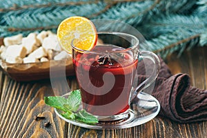 Hot red mulled wine on wooden background decorated blue spruce branches, with christmas spices, orange slice, fresh mint, cloves