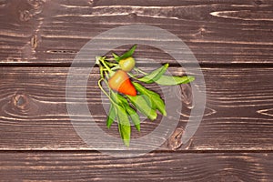 Hot red orange chili pepper on brown wood
