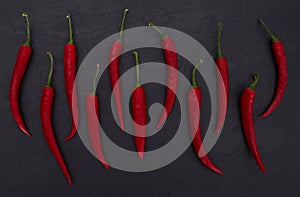 Hot red peppers on black slate background