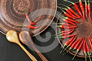 Hot red peppers in a clay pot on the kitchen table for cooking. The circle of spicy red chilli