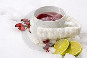 Hot red tea from rose hips and lemon outside in the snow, winter