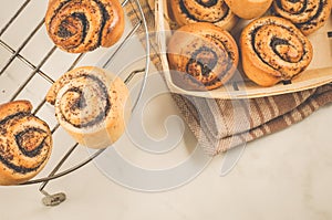 Hot rolls with poppy/fresh rolls with poppy on a metal lattice and in a wooden box. Top view