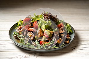 hot salad with beef fillet and grilled vegetables served on a plate on a light table in a restaurant