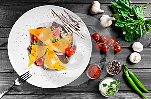 Hot salad with beef steak chargrilled to medium rare with cherry tomatoes, mushrooms and cheese on dark wooden background photo